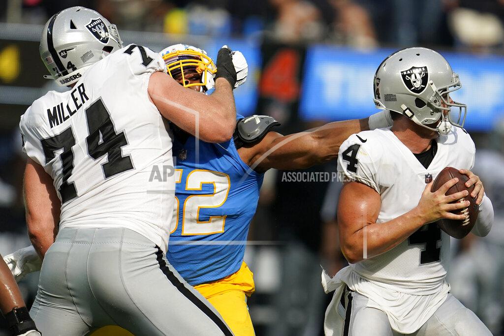 Marcio Jose Sanchez Los Angeles Chargers linebacker Khalil Mack, middle, reaches for Las Vegas Raiders quarterback Derek Carr (4) while being blocked by offensive tackle Kolton Miller (74) during the second half of an NFL football game in Inglewood, Calif., Sunday, Sept. 11, 2022. (AP Photo/Marcio Jose Sanchez)