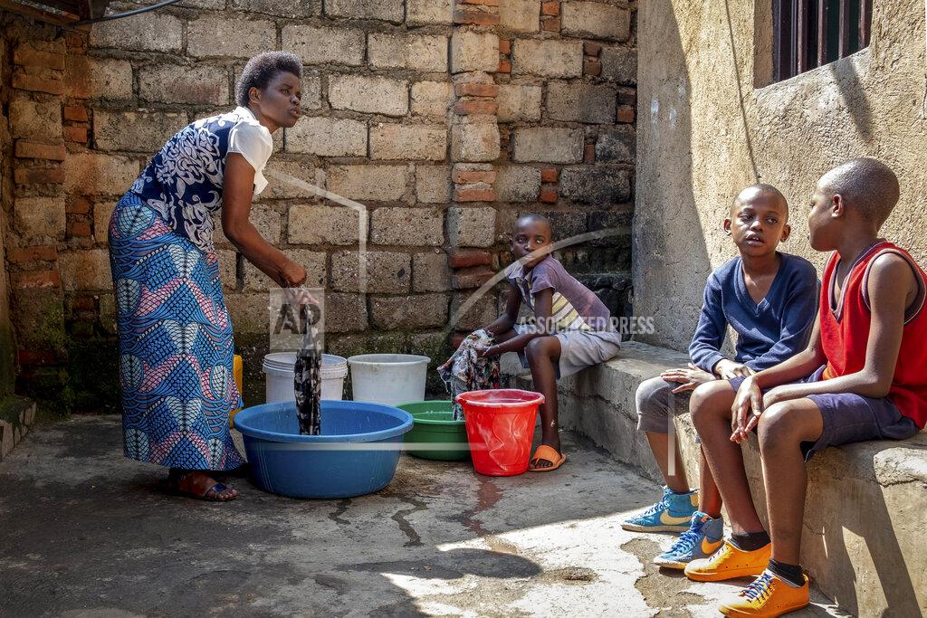 Uncredited Tresor Ndizihiwe, 12, center, helps wash clothes with his mother, Jacqueline Mukantwari, left, and brothers, right, at their house in Kigali, Rwanda on Tuesday, April 21, 2020. Mukantwari is paid $50 a month as a schoolteacher, but used to earn extra money giving private lessons. That business has dried up amid the COVID-19 coronavirus lockdown, and the family gets food parcels from the government twice a month. (AP Photo)