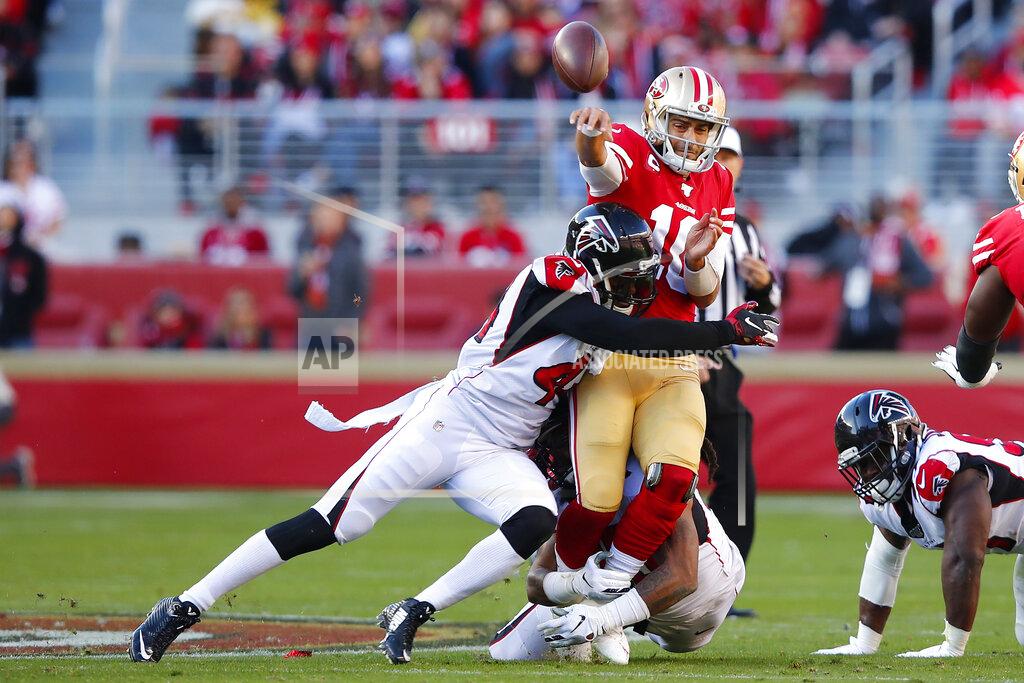 John Hefti San Francisco 49ers quarterback Jimmy Garoppolo, top, is hit while passing by Atlanta Falcons defensive end Vic Beasley, left, and defensive end Adrian Clayborn, bottom center, during the first half of an NFL football game in Santa Clara, Calif., Sunday, Dec. 15, 2019. (AP Photo/John Hefti)