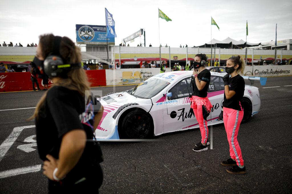 Natacha Pisarenko Vitarti Girl's Team mechanics Estenania Onofrio, left, Paula Salazar, center, and Victoria Pascual stand next to driver Karina Dobal before the start of their first race at the Oscar y Juan Galvez track in Buenos Aires, Argentina, Sunday, April 4, 2021. The women are part of the first entirely female team to take part in a national racing competition in Argentina. (AP Photo/Natacha Pisarenko)