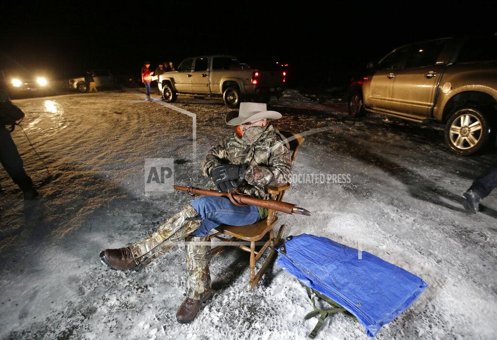 Rick Bowmer FILE - In this Jan. 5, 2016 file photo Arizona rancher LaVoy Finicum holds a gun as he guards the Malheur National Wildlife Refuge near Burns, Ore. Finicum, one of the leaders of the armed takeover of the refuge, was later shot by state police officers after he fled an attempted police stop. Experts say right-wing extremism like the Malheur takeover had previously mostly played out in isolated pockets or smaller cities in America before the deadly assault by rioters on the U.S. Capitol earlier this month. (AP Photo/Rick Bowmer, File)