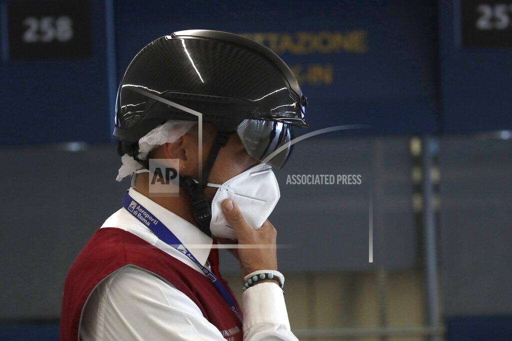 Alessandra Tarantino An airport security member wears a smart helmet scanner which measures the body temperature of passengers for possible coronavirus symptoms, Rome's Fiumicino airport, Wednesday, June 3, 2020. Rome’s Fiumicino airport sprang back to life on Wednesday as Italy opened regional and international borders in the final phase of easing its long coronavirus lockdown, allowing families and loved ones separated by the global pandemic to finally reunite. (AP Photo/Alessandra Tarantino)