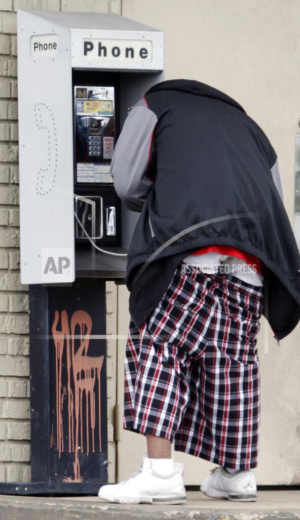 FILE - This May 8, 2009, file photo shows a man who declined to be identified, wearing saggy pants, as he dials a phone in Nashville, Tenn. After 13 years, a South Florida city has overturned a ban on “saggy pants” — bottoms that reveal the wearer's underwear. The Opa-locka City Commission voted Wednesday, Sept. 9, 2020, on a 4-1 vote to repeal both the original 2007 legislation and a 2013 ordinance that said women, not just men, could receive civil citations for wearing pants that exposed their undergarments. (AP Photo/Mark Humphrey, File)