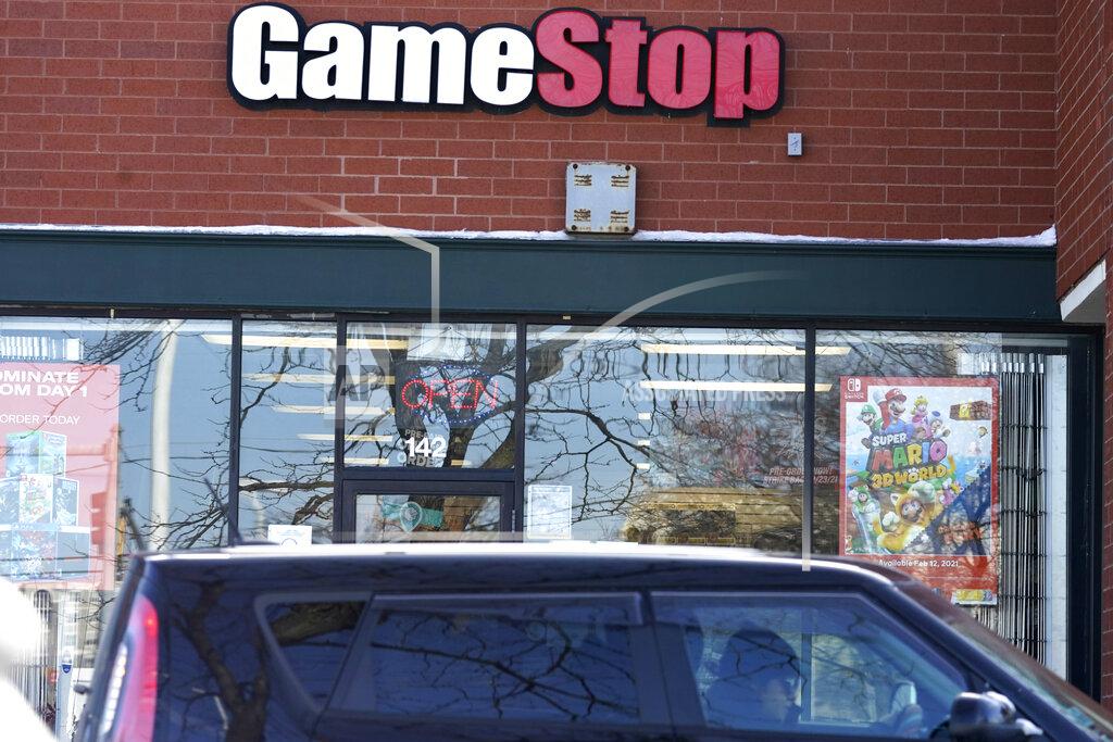 A vehicle passes in front of a GameStop store in Vernon Hills, Ill., Thursday, Jan. 28, 2021. The online trading platform Robinhood is moving to restrict trading in GameStop and other stocks that have soared recently due to rabid buying by smaller investors. GameStop stock has rocketed from below $20 earlier this month to close around $350 Wednesday as a volunteer army of investors on social media challenged big institutions who had placed market bets that the stock would fall. (AP Photo/Nam Y. Huh)
