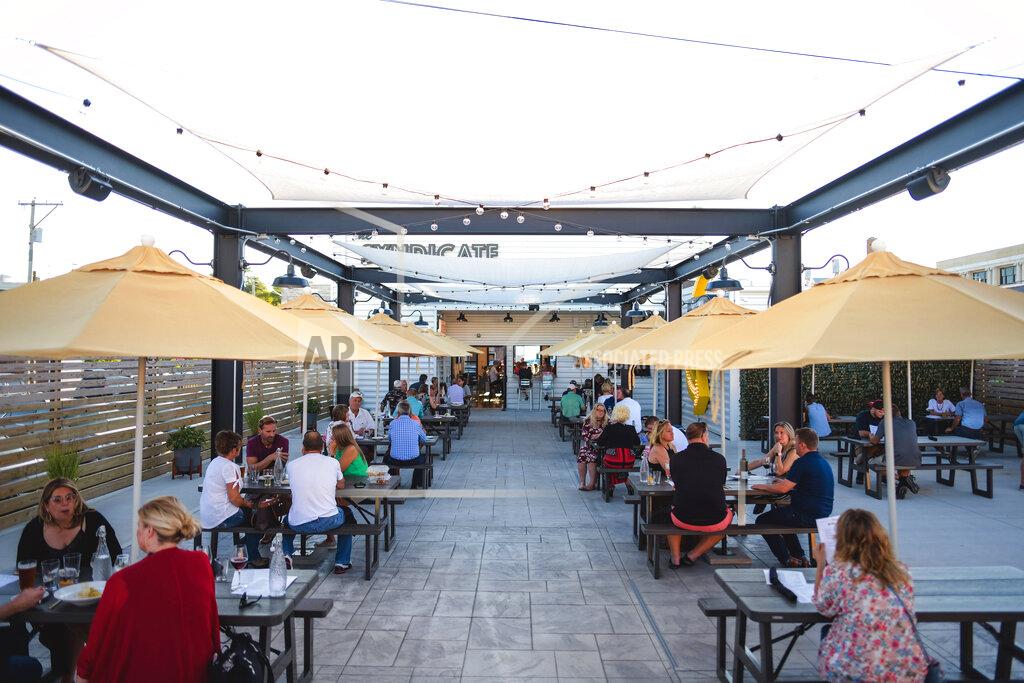 Susie Jarvis This photo provided by Adam M. Rammel shows the beer garden at The Syndicate on Aug. 20, 2020 in Bellefontaine, Ohio. Many restaurants, event planners and even companies like distillers and corporate gift manufacturers face weaker revenues although the holiday season is approaching. Owners contending with government restrictions or crumbling demand are trying to hold on _ some are creating new products and services or desperately searching for new customers. (Susie Jarvis/Adam M. Rammel via AP)