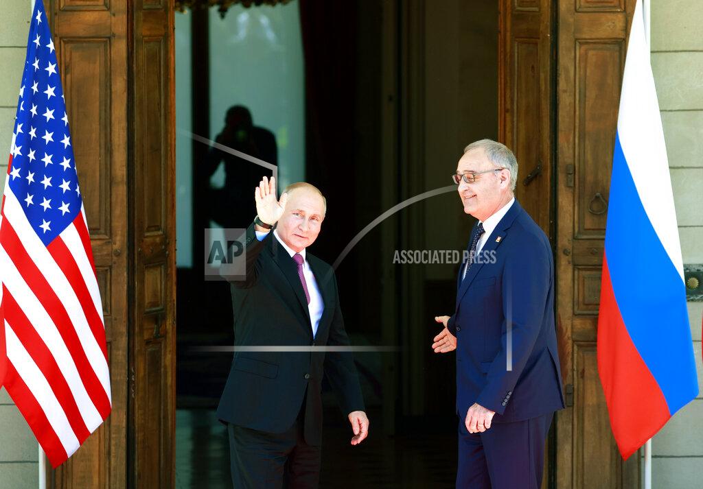 Russia's President Vladimir Putin, left, waves next to Swiss President Guy Parmelin, right, as he arrives at Villa La Grange for the U.S.-Russia summit in Geneva, Switzerland, June 16, 2021. (Denis Balibouse/Pool Photo via AP)