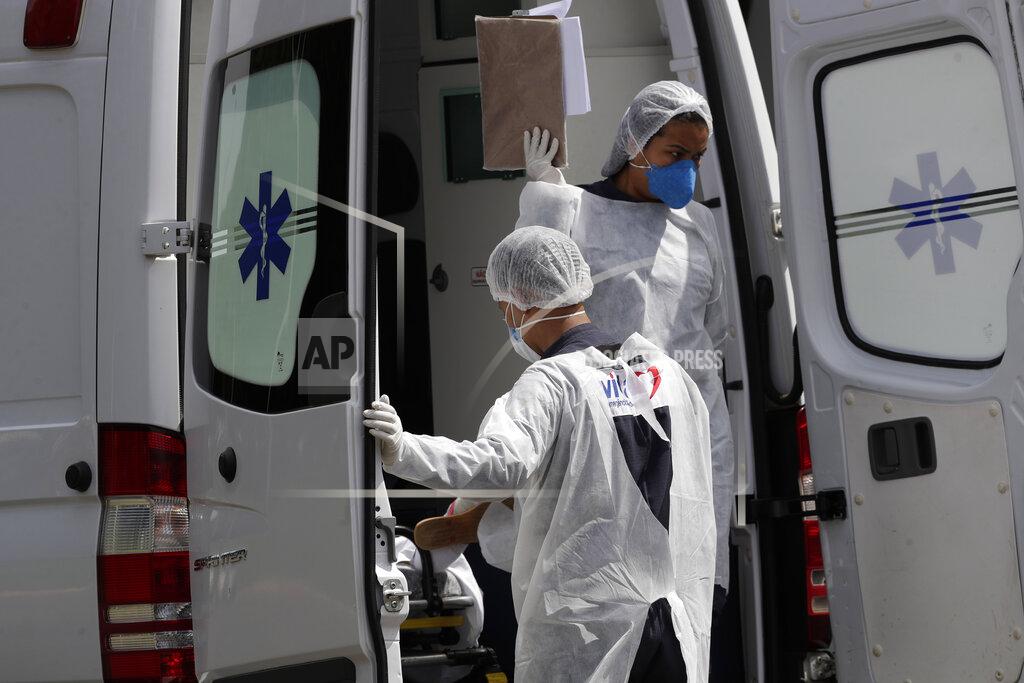 Eraldo Peres FILE - In this April 14, 2021, file photo, healthcare workers exit an ambulance carrying a patient suspected of having COVID-19 as they arrive at the HRAN public hospital in Brasilia, Brazil. The picture is still grim in parts of Europe and Asia as variants of the virus fuel an increase in new cases and the worldwide death toll closes in on 3 million.(AP Photo/Eraldo Peres, File)