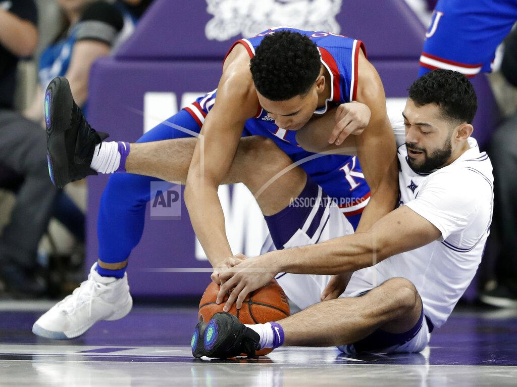 Tony Gutierrez Kansas guard Devon Dotson, top, and TCU guard Alex Robinson, bottom, wrestle for control of a loose ball in the first half of an NCAA college basketball game in Fort Worth, Texas, Monday, Feb. 11, 2019. (AP Photo/Tony Gutierrez)
