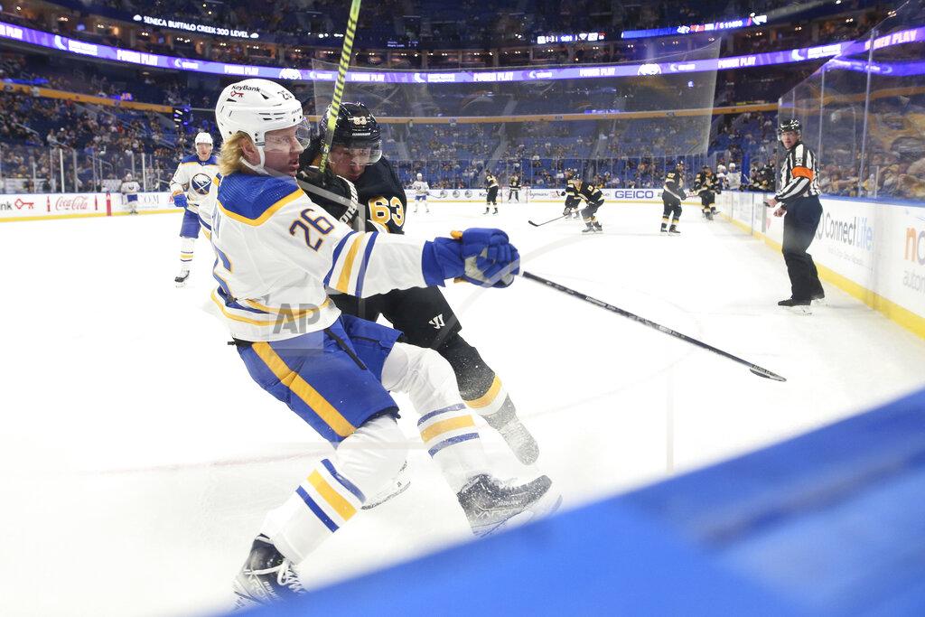 Joshua Bessex Boston Bruins center Brad Marchand (63) checks Buffalo Sabres defenseman Rasmus Dahlin (26) to the ice during the second period of an NHL hockey game Friday, Oct. 22, 2021, in Buffalo, N.Y. (AP Photo/Joshua Bessex)