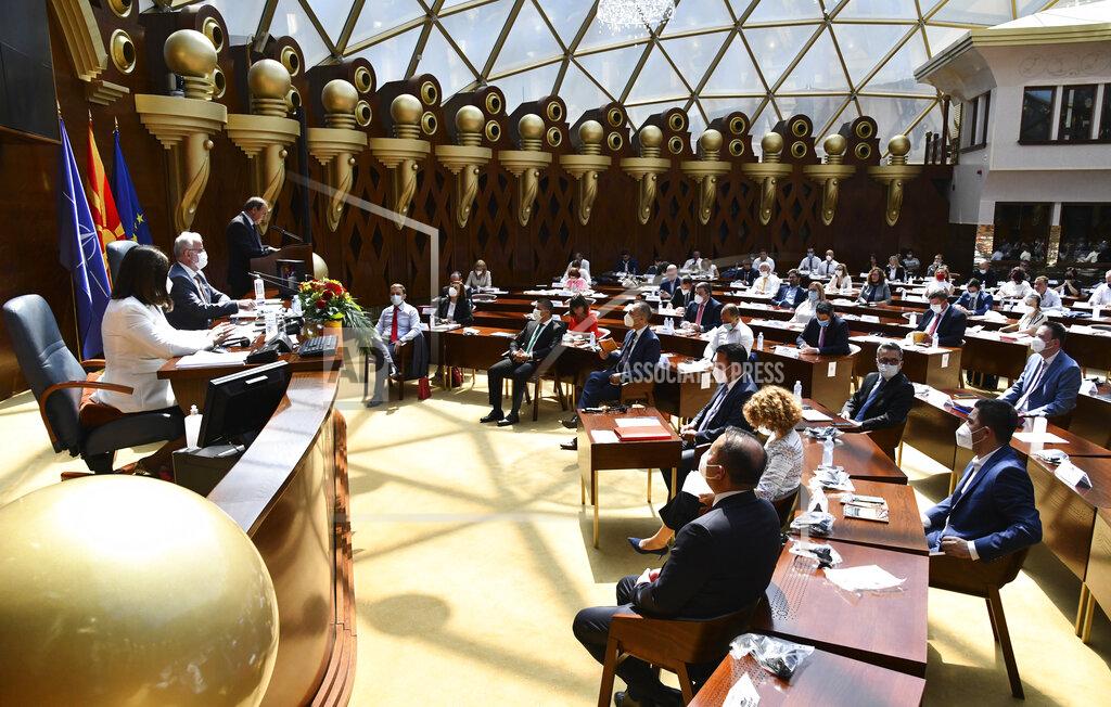 Uncredited In this photo provided by thePress Service of the Parliament of North Macedonia, lawmakers and candidates for ministers wearing face masks and social distancing to protect themselves from the coronavirus, attend the session of the Parliament dedicated for election of the new government, in a dome hall at the parliament building in Skopje, North Macedonia, Sunday, Aug. 30, 2020. North Macedonia’s parliament continued its debate on a vote of confidence for a new left-wing coalition government after the Social Democrats and their ethnic Albanian partners secured a majority in parliament in July's general election. (Press Service of the Parliament of North Macedonia via AP)