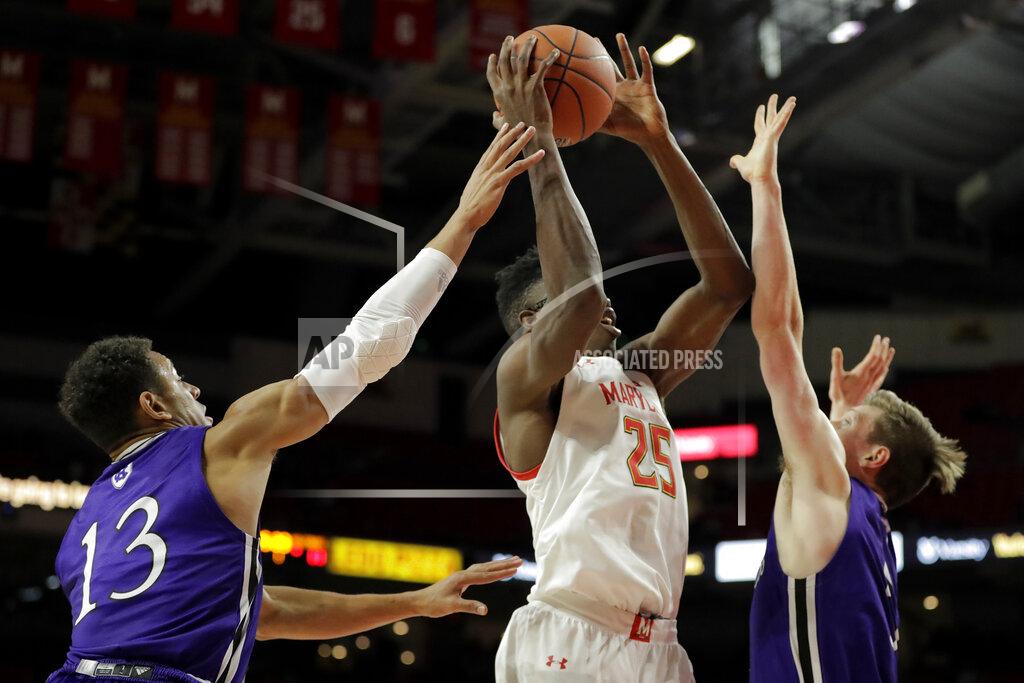 Julio Cortez Maryland forward Jalen Smith (25) goes up for a shot against Holy Cross forward Marlon Hargis (13) and forward Connor Niego (5) during the first half of an NCAA college basketball game, Tuesday, Nov. 5, 2019, in College Park, Md. (AP Photo/Julio Cortez)
