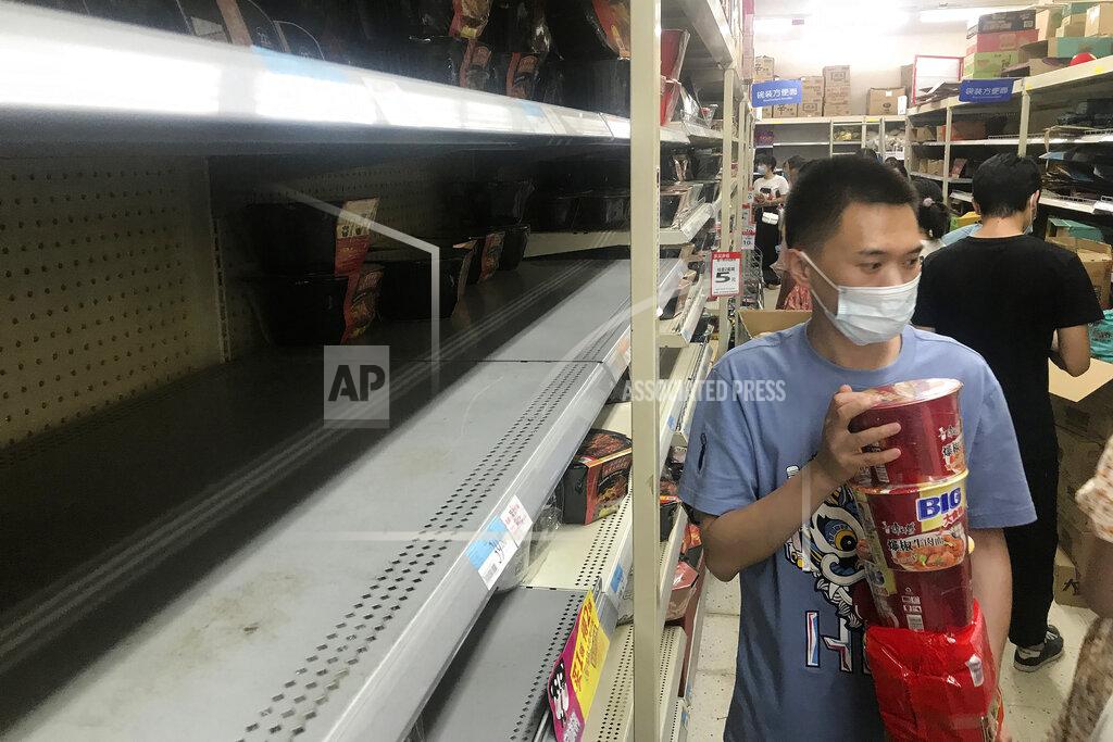 Uncredited Shelves are empty as residents rush to stock up on necessities at a supermarket after authorities lockdown near residential blocks to prevent the spread of the COVID-19 in Wuhan city in central China's Hubei province Monday, Aug. 2, 2021. Chinese authorities announced Tuesday the mass testing of Wuhan as an unusually wide series of COVID-19 outbreaks reached the city where the disease was first detected in late 2019. (Chinatopix via AP)