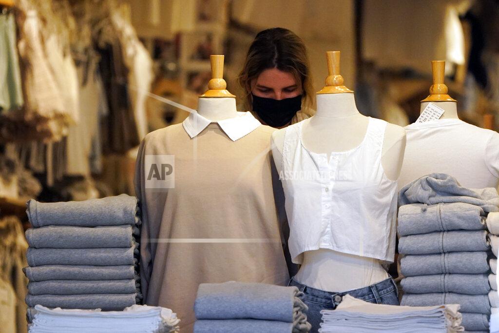 Marcio Jose Sanchez A worker wears a mask while straightening up a display amid the COVID-19 pandemic on The Promenade Wednesday, June 9, 2021, in Santa Monica, Calif. (AP Photo/Marcio Jose Sanchez)