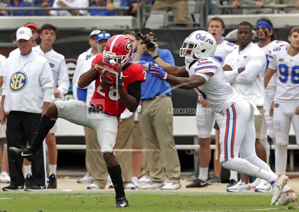 John Raoux Georgia defensive back Tyrique McGhee, left, intercepts a pass intended for Florida wide receiver Josh Hammond, right, during the first half of an NCAA college football game Saturday, Oct. 27, 2018, in Jacksonville, Fla. (AP Photo/John Raoux)