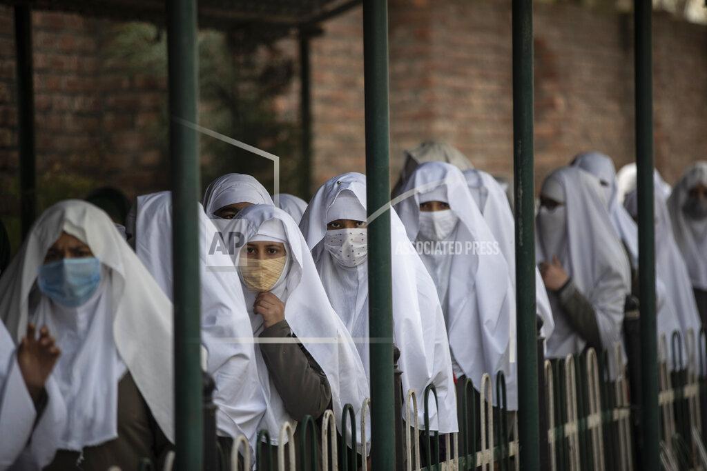 Mukhtar Khan Kashmiri students wearing face masks arrive to attend a school in Srinagar, Indian controlled Kashmir, Monday, March 15, 2021. Schools reopened for the lower grades Monday in Indian-controlled Kashmir, eleven months after being closed due to the coronavirus pandemic. (AP Photo/Mukhtar Khan)