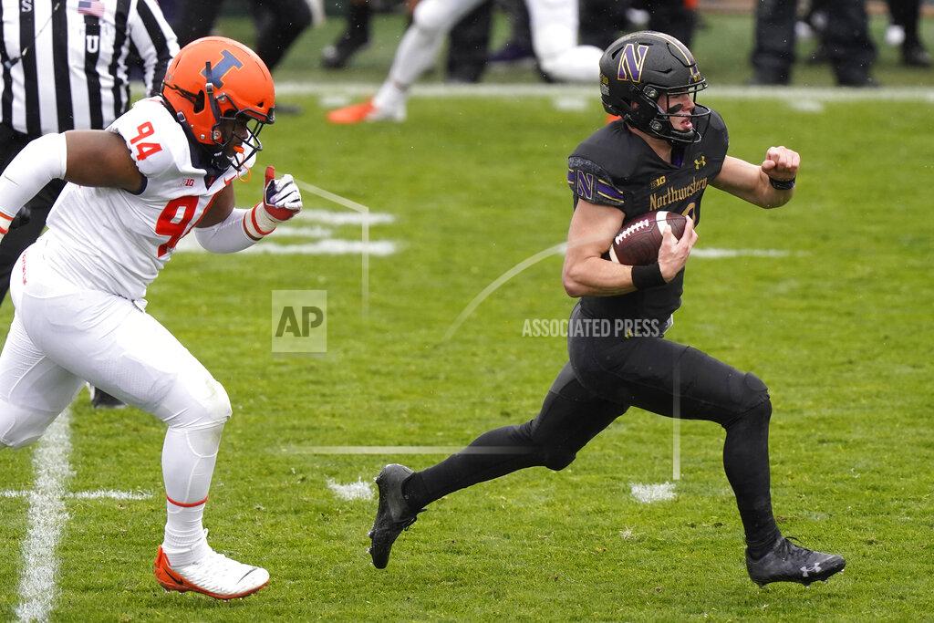 Nam Y. Huh Northwestern quarterback Peyton Ramsey, right, runs with the ball past Illinois defensive line Jer'Zhan Newton during the first half of an NCAA college basketball game in Evanston, Ill., Saturday, Dec. 12, 2020. (AP Photo/Nam Y. Huh)
