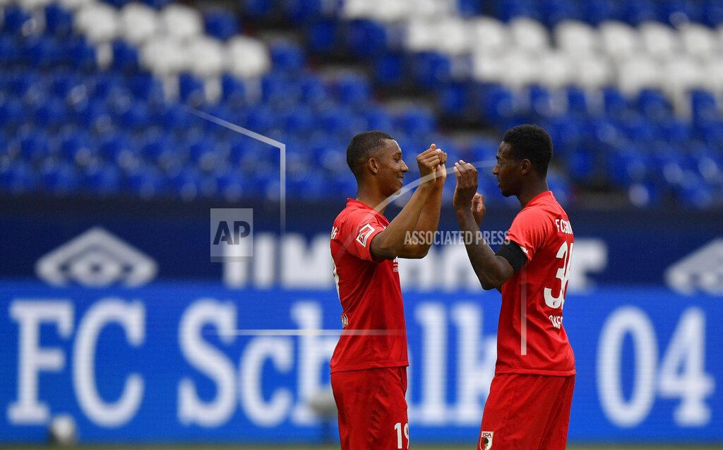 Martin Meissner Augsburg's Felix Uduokhai, left, and Augsburg's Reece Oxford celebrate at the end of the German Bundesliga soccer match between FC Schalke 04 and FC Augsburg at the Veltins-Arena in Gelsenkirchen, Germany, Sunday, May 24, 2020. The German Bundesliga becomes the world's first major soccer league to resume after a two-month suspension because of the coronavirus pandemic. (AP Photo/Martin Meissner, Pool)