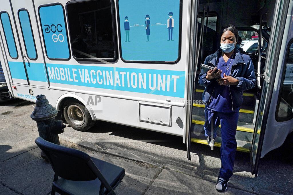 Kathy Willens FILE — In this March 29, 2021, file photo, a health care worker steps out of a mobile vaccination van parked on a street corner in the Sunset Park neighborhood of Brooklyn, in New York. New York City hopes to begin offering coronavirus inoculations to tourists by stationing vaccination vans in Times Square and other visitor-heavy spots, Mayor Bill de Blasio said Thursday, May 6, 2021. (AP Photo/Kathy Willens, File)