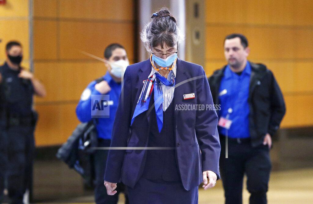Workers at Seattle-Tacoma International Airport, most wearing masks, walk out of a secure area, Monday, May 18, 2020, in SeaTac, Wash. Monday was the first day that travellers at the airport were required to wear face coverings in the public areas there. The Port of Seattle has encouraged its employees to wear face coverings, and all federal agencies that operate at the airport require their employees to wear face coverings. All airlines operating at SeaTac require employees and passengers to wear face coverings. (AP Photo/Elaine Thompson)