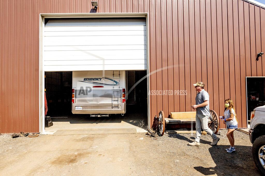 Noah Berger Woody and Luna Faircloth get a first look at a donated RV before delivering it to a Dixie Fire victim, Sunday, Sept. 5, 2021, in Sierra County, Calif. (AP Photo/Noah Berger)