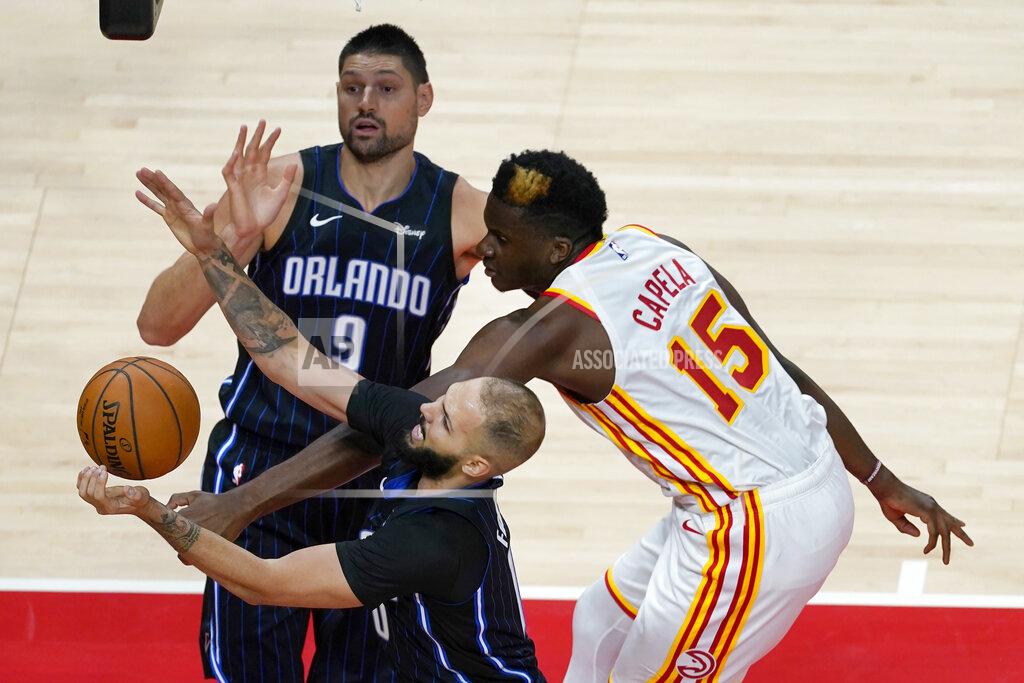 John Bazemore Orlando Magic guard Evan Fournier (10) and Atlanta Hawks center Clint Capela (15) reach for a loose ball as Orlando' Nikola Vucevic (9) watches during the first half of an NBA preseason basketball game Friday, Dec. 11, 2020, in Atlanta. (AP Photo/John Bazemore)