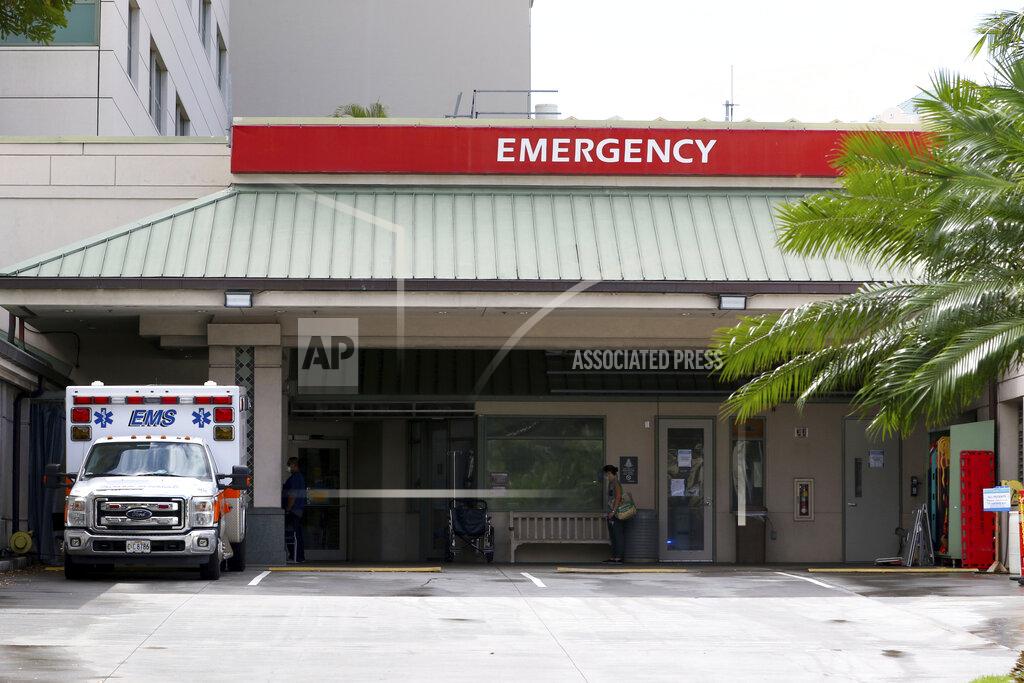 Caleb Jones FILE — In this Aug. 24, 2021, file photo an ambulance sits outside the emergency room at The Queen's Medical Center in Honolulu. Health care workers in Hawaii say a lack of government action is worsening an already crippling surge of coronavirus cases in the islands, and without effective policy changes the state's limited hospitals could face a grim crisis. (AP Photo/Caleb Jones, File)
