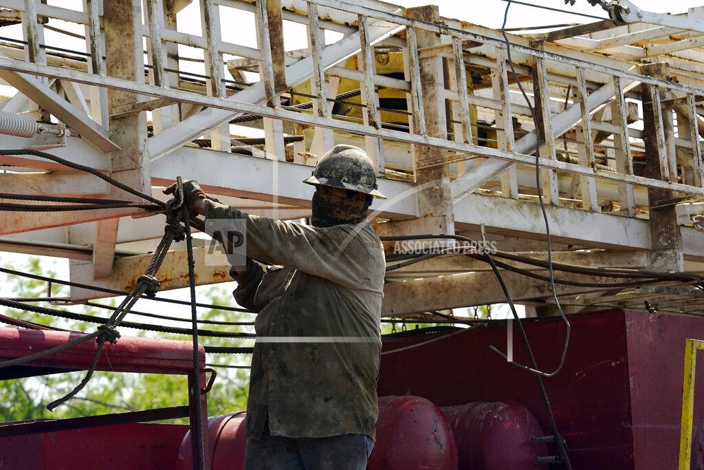 Eric Gay A well worker moves equipment at a site on Molly Rooke's ranch where an orphaned well was plugged, Tuesday, May 18, 2021, near Refugio, Texas. Oil and gas drilling began on the ranch in the 1920s and there were dozens of orphaned wells that needed to be plugged for safety and environmental protection. (AP Photo/Eric Gay)
