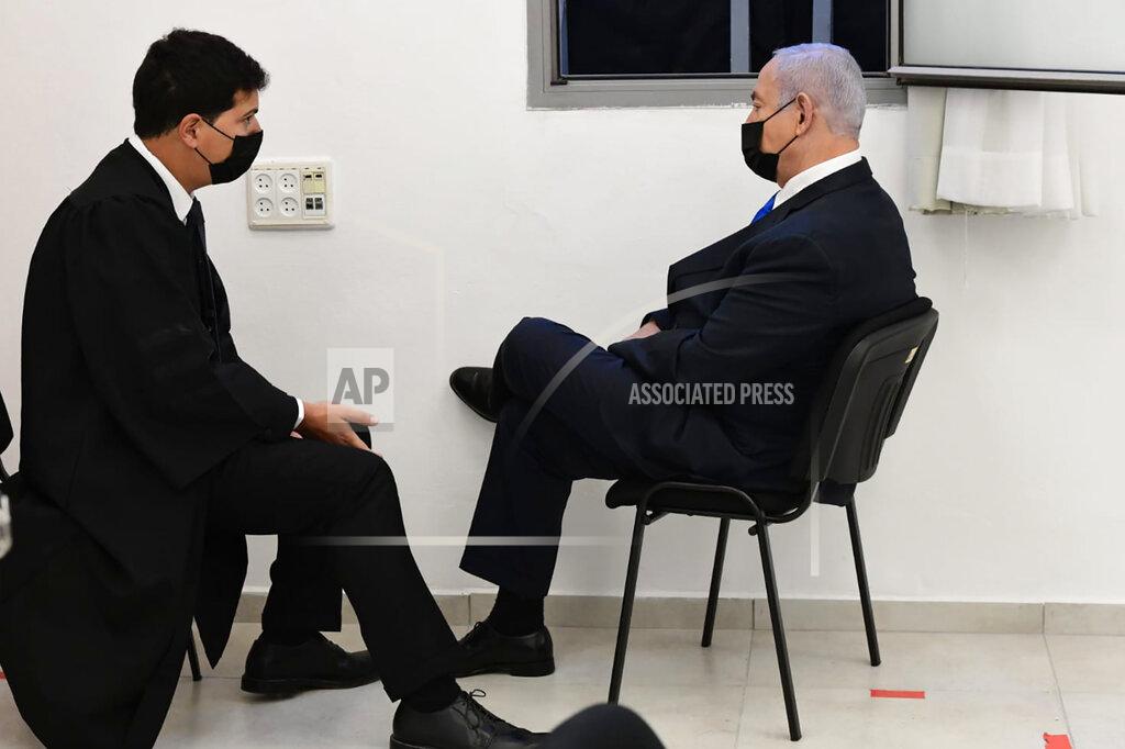 Reuven Castro Israeli Prime Minister Benjamin Netanyahu speaks with his lawyers prior to a hearing at the district court in Jerusalem, Monday, Feb. 8, 2021. Netanyahu appeared in a Jerusalem courtroom Monday to respond formally to corruption charges just weeks before national elections in which he hopes to extend his 12-year rule. (AP Photo/Reuven Castro, Pool)