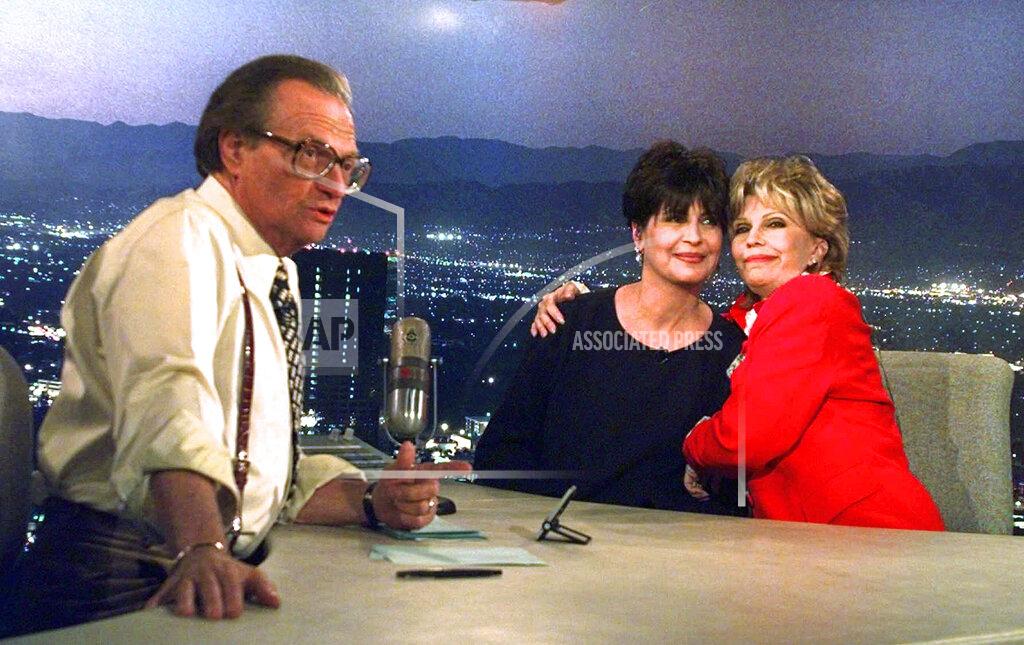 Susan Sterner FILE - In this Dec. 12, 1997 file photo, Tina Sinatra, center, and Nancy Sinatra, right, daughters of the singer Frank Sinatra, joke around on CNN's Los Angeles set of "Larry King Live" as host Larry King makes preparations. King, who interviewed presidents, movie stars and ordinary Joes during a half-century in broadcasting, has died at age 87. Ora Media, the studio and network he co-founded, tweeted that King died Saturday, Jan. 23, 2021 morning at Cedars-Sinai Medical Center in Los Angeles. (AP Photo/Susan Sterner)