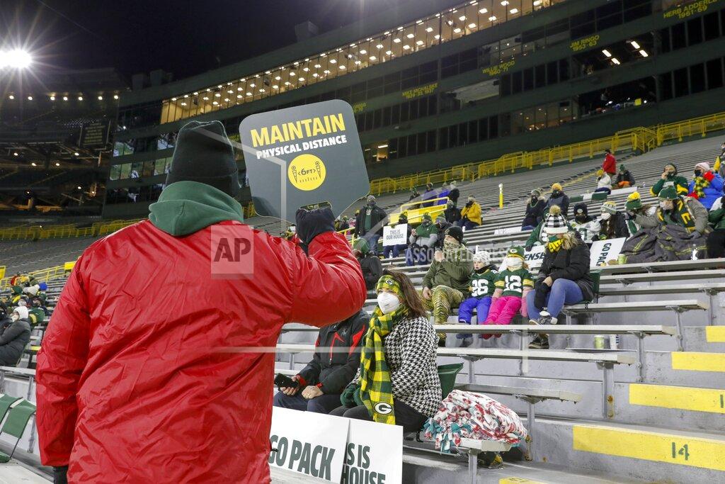 Mike Roemer A worker reminds a small croud to maintain tphysical distance during the first half of an NFL football game between the Green Bay Packers and the Chicago Bears Sunday, Nov. 29, 2020, in Green Bay, Wis. (AP Photo/Mike Roemer)