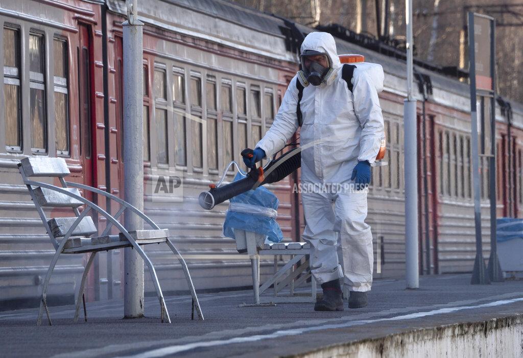 Dmitri Lovetsky A member from a local veterinary service wearing protective suit sprays disinfectant on a platform of the railway station in Ladozhskoye Ozero village outside St. Petersburg, Russia, Saturday, April 4, 2020. The new coronavirus causes mild or moderate symptoms for most people, but for some, especially older adults and people with existing health problems, it can cause more severe illness or death. (AP Photo/Dmitri Lovetsky)