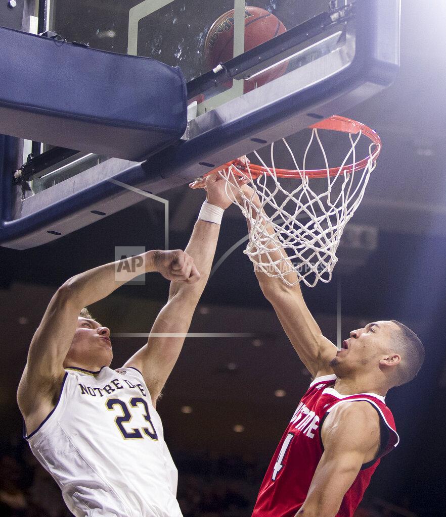 Robert Franklin North Carolina State's Jericole Hellems, right, fouls Notre Dame's Dane Goodwin (23) on a dunk attempt during the second half of an NCAA college basketball game Saturday, Jan. 19, 2019, in South Bend, Ind. North Carolina State won 77-73. (AP Photo/Robert Franklin)