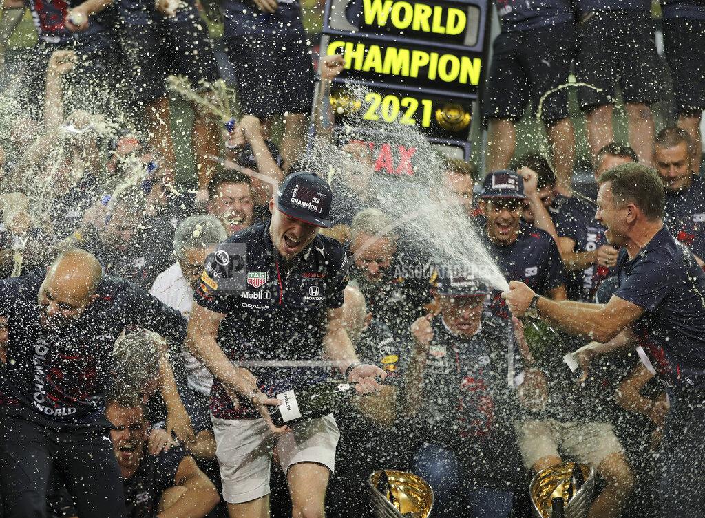 Kamran Jebreili Red Bull driver Max Verstappen of the Netherlands, left, celebrates with Red Bull team chief Christian Horner, right, and his team in the pit lane after becoming F1 drivers world champion after winning the Formula One Abu Dhabi Grand Prix in Abu Dhabi, United Arab Emirates, Sunday, Dec. 12. 2021. The most dramatic Formula One season in years ended, of course, in one of the most dramatic finishes possible when Max Verstappen snatched the world championship away from Lewis Hamilton with a pass on the final lap of the Abu Dhabi GP. (AP Photo/Kamran Jebreili)