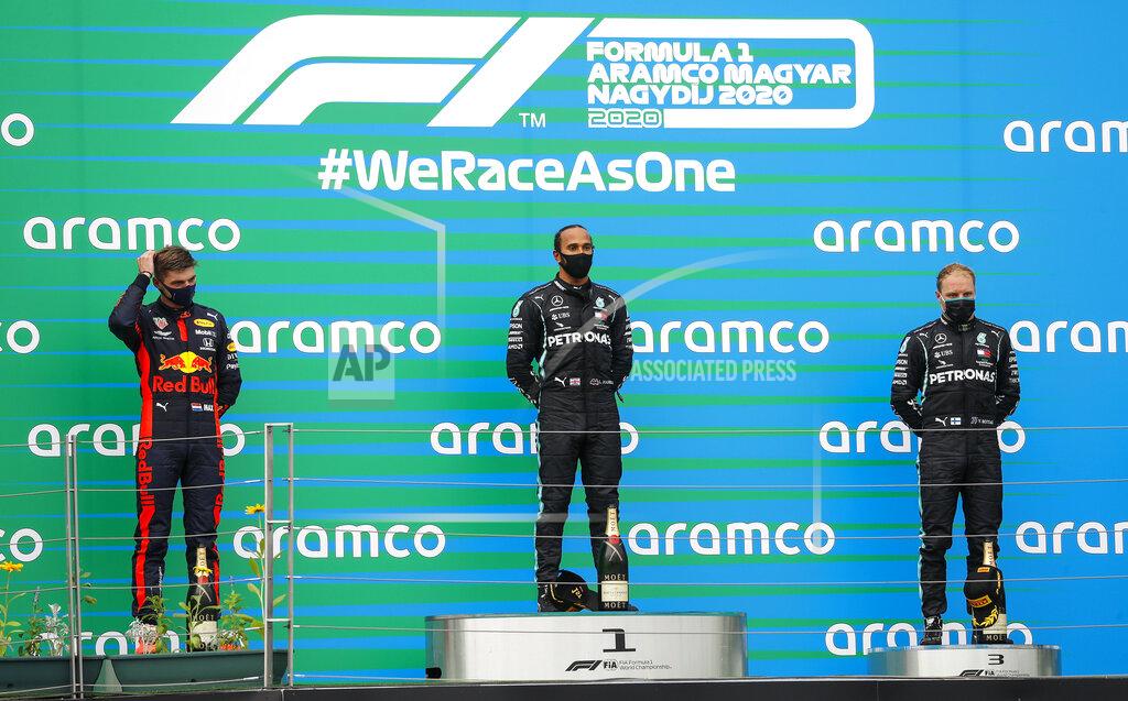 Leonhard Foeger Winner Mercedes driver Lewis Hamilton of Britain, center, stands beside second placed Red Bull driver Max Verstappen of the Netherlands, left, and third placed Mercedes driver Valtteri Bottas of Finland, right, on the podium after the Hungarian Formula One Grand Prix race at the Hungaroring racetrack in Mogyorod, Hungary, Sunday, July 19, 2020. (Leonhard Foeger/Pool via AP)