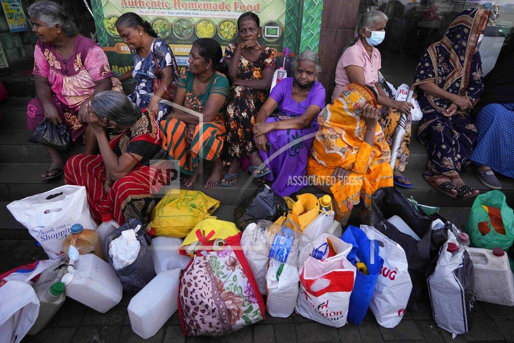 Eranga Jayawardena Women wait near an empty fuel station hoping to buy kerosene oil for cooking in Colombo, Sri Lanka, Thursday, May 26, 2022. Sri Lankans for months have been forced to stand in long lines to buy scarce essentials, with many returning home empty-handed. There is a severe shortage of many goods, from food, cooking gas, medicine and fuel to toilet paper and matchsticks.(AP Photo/Eranga Jayawardena)