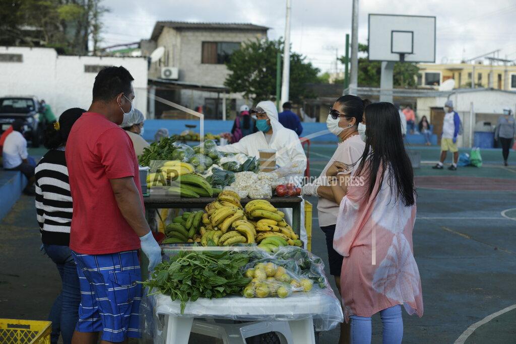 Adrian Vasquez In this May 2, 2020 photo, local farmers, wearing protective as a measure to curb the spread of the new coronavirus, sell their products to residents, in San Cristobal, Galapagos Islands, Ecuador. For many islanders, the pandemic has left them to meditate on their relationships with nature, industry and travel. Some wonder if they should continue to remain so dependent on tourism, while others say it highlights the need for self-sufficiency. (AP Photo/Adrian Vasquez)