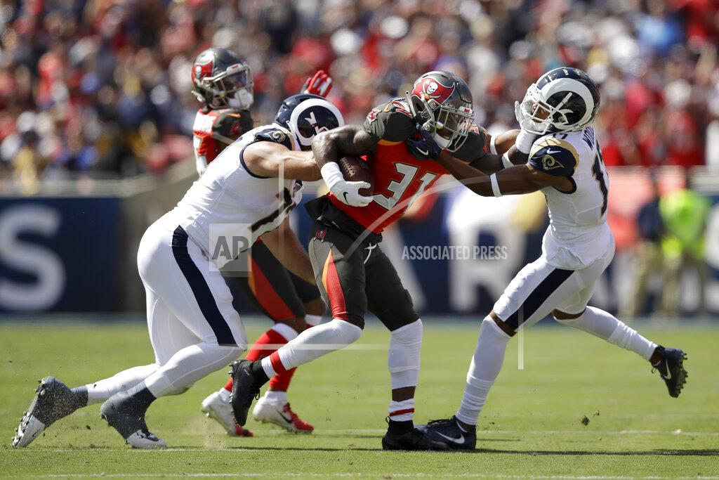Marcio Jose Sanchez Tampa Bay Buccaneers free safety Jordan Whitehead, middle, is tackled by Los Angeles Rams offensive tackle Andrew Whitworth, left. And wide receiver Robert Woods after an interception during the first of an NFL football game Sunday, Sept. 29, 2019, in Los Angeles. (AP Photo/Marcio Jose Sanchez)