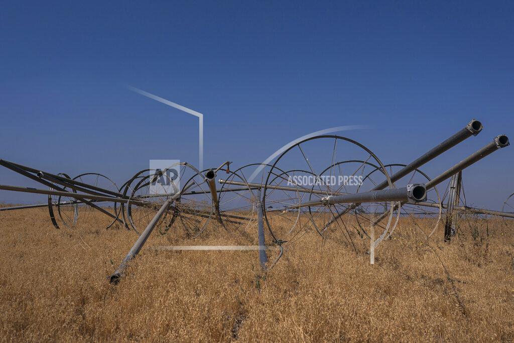 Nathan Howard Dry and inactive irrigation pipes are stored in a fallowed field in the North Unit Irrigation District on Tuesday, Aug. 31, 2021, near Madras, Ore. Cracked dirt lines empty irrigation canals, and dust devils and tumbleweeds punctuate a landscape in shades of brown. (AP Photo/Nathan Howard)