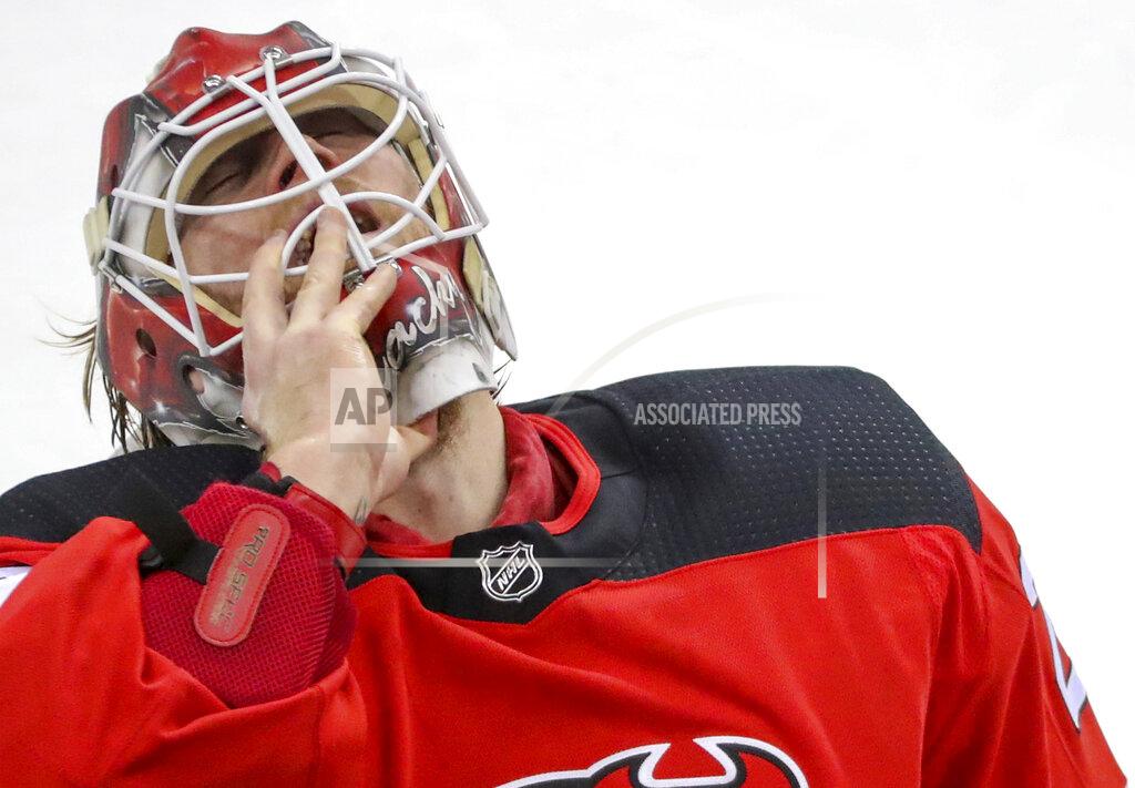 Andrew Mills New Jersey Devils goaltender Mackenzie Blackwood (29) pulls off his mask during a timeout during the first period of an NHL game against the Washington Capitals Sunday, Feb. 28, 2021, in Newark, N.J. (Andrew Mills/NJ Advance Media via AP)