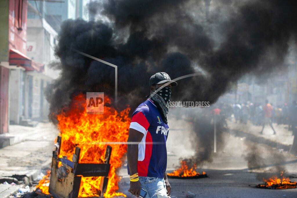 Dieu Nalio Chery A protester walks past burning barricades during a protest demanding the resignation of President Jovenel Moise in Port-au-Prince, Haiti, Saturday, Oct. 17, 2020. The country is currently experiencing a political impasse without a parliament and is now run entirely by decree under Moise. ( AP Photo/Dieu Nalio Chery)