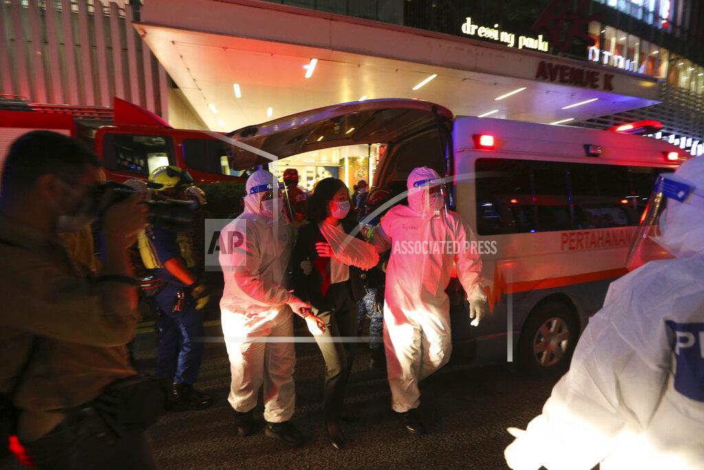 Uncredited Rescue personnel help an injured passenger at KLCC station after two light rail trains collided in a tunnel, injuring more than 200 people in Kuala Lumpur, Malaysia, Monday, May 24, 2021. (AP Photo)