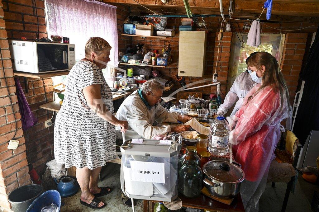 Uncredited Members of an election commission come to an elderly family to help them attend a voting at their house in Starozolotovsky village, 160 km (100 miles) north of Rostov-on-Don during the Parliamentary elections , Russia, Saturday, Sept. 18, 2021. Sunday is the last of three days voting for a new parliament, but there seems to be no expectation that United Russia, the party devoted to President Vladimir Putin, will lose its dominance in the State Duma. (AP Photo)