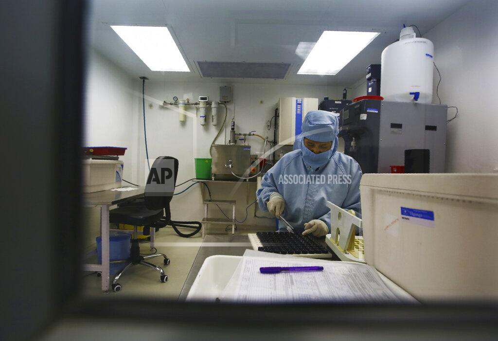 Niranjan Shrestha A Nepalese hospital staff works at a laboratory at the Tilganga Eye Center in Kathmandu, Nepal, March 26, 2021. Nepal’s “God of Sight” eye doctor renowned for his innovative and inexpensive cataract surgery for the poor is taking his work beyond the Himalayan mountains to other parts of the world so there is no more unnecessary blindness in the world. Dr. Sanduk Ruit, who has won many awards for his work and performed some 130,000 cataract surgery in the past three decades, is aiming to expand his work beyond the borders of his home country and the region to go globally. (AP Photo/Niranjan Shrestha)
