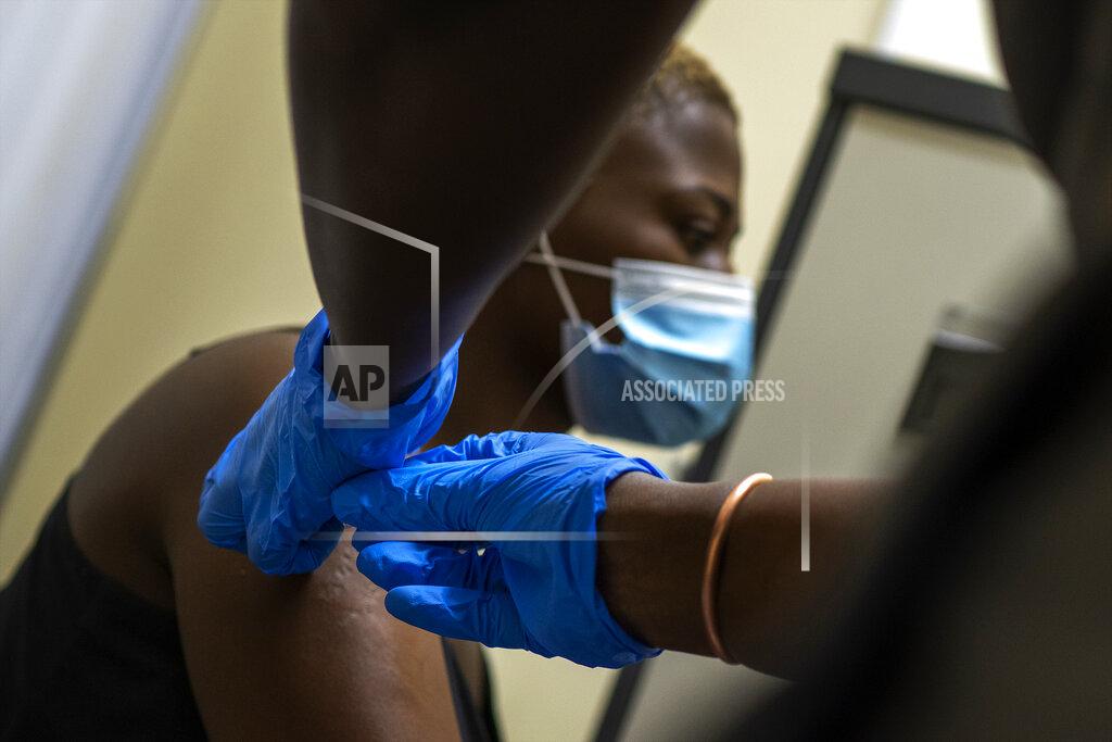 Jerome Delay Volunteer Thabisle Khlatshwayo, who received her first shot for a COVID-19 vaccine trial, receives her second shot at a vaccine trial facility set at Soweto's Chris Sani Baragwanath Hospital outside Johannesburg, South Africa, Monday Nov. 30, 2020. Over 2000 South African volunteers are on AstraZeneca's experimental coronavirus vaccine trial. (AP Photo/Jerome Delay)