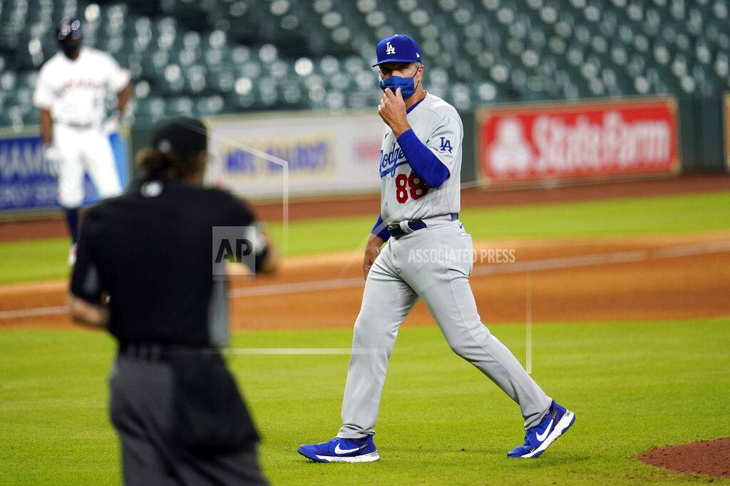 David J. Phillip Los Angeles Dodgers bench coach Bob Green (88) talks to home plate umpire Chris Guccione, left, after making a pitching change during the fifth inning of a baseball game against the Houston Astros Wednesday, July 29, 2020, in Houston. Los Angeles Dodgers manager Dave Roberts is serving a one-game suspension. (AP Photo/David J. Phillip)