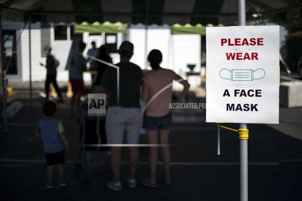 David Goldman Customers with masks line up at a Brickley's Ice Cream shop, one of two stores, in Narragansett, R.I., Wednesday, July 29, 2020. The other nearby location closed when teenage workers were harassed by customers who refused to wear a mask or socially distance. Disputes over masks and mask mandates are playing out at businesses, on public transportation and in public places across America and other nations. (AP Photo/David Goldman)