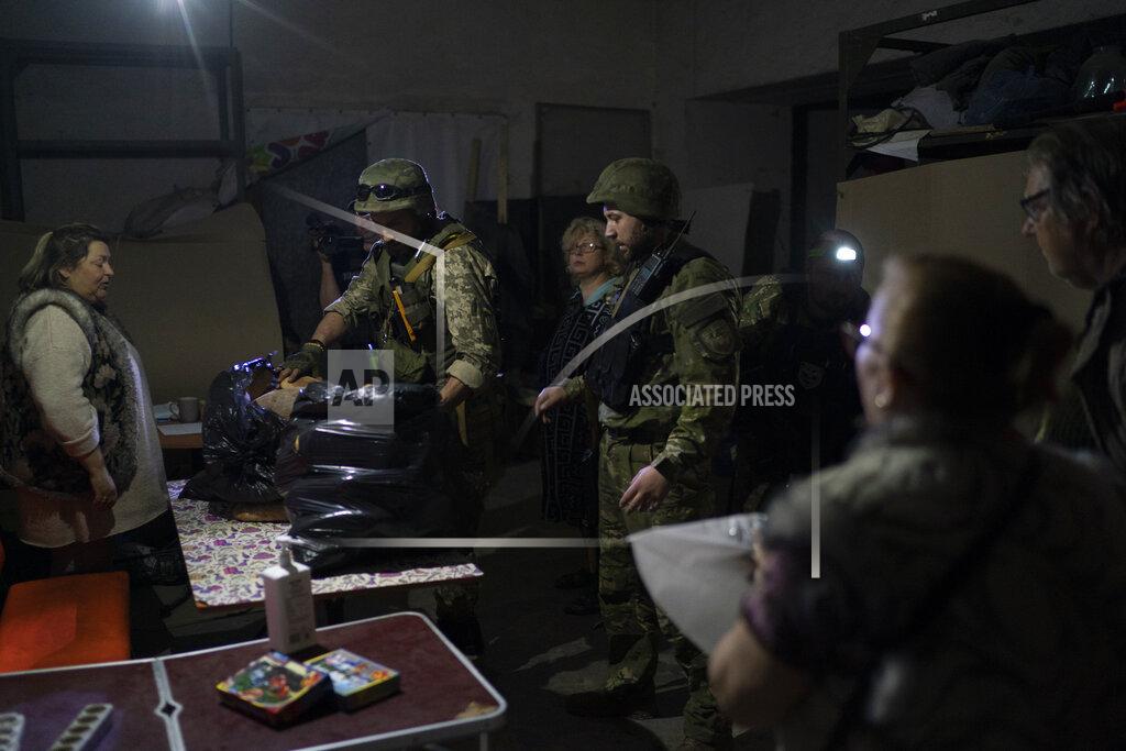 Leo Correa A special task force policemen deliver bags of breads donated to the people who are living inside a basement used as a bomb shelter, during Russian attacks in Severodonetsk, Luhansk region, Ukraine, Friday, May 13, 2022. (AP Photo/Leo Correa)