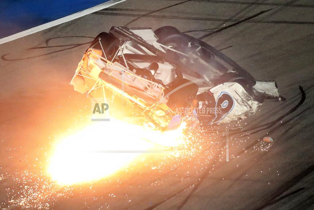 El auto de Ryan Newman se desliza por la pista envuelto en llamas tras una colisión y volcadura en la recta final de las 500 Millas de Daytona, el lunes 17 de febrero de 2020 (AP Foto/David Graham)