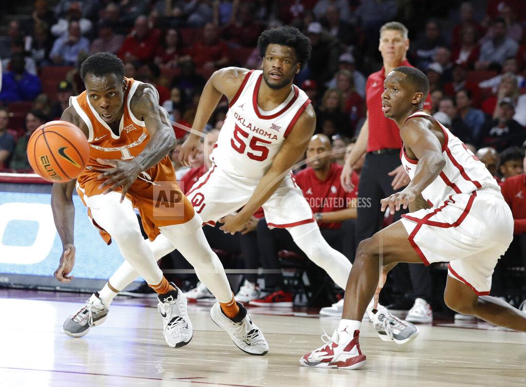 Alonzo Adams Texas guard Andrew Jones (1) races after a loose ball as Oklahoma guard Elijah Harkless (55) watches during the first half of an NCAA college basketball game Tuesday, Feb. 15, 2022, in Norman, Okla. (AP Photo/Alonzo Adams)