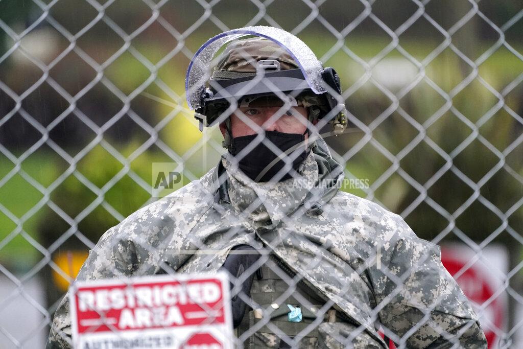 Ted S. Warren A member of the Washington National Guard stands at a fence surrounding the Capitol in anticipation of protests Monday, Jan. 11, 2021, in Olympia, Wash. State capitols across the country are under heightened security after the siege of the U.S. Capitol last week. (AP Photo/Ted S. Warren)